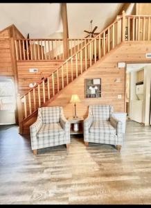 un soggiorno con due sedie e una scala di Enchanted Farmhouse Cabin a Branson