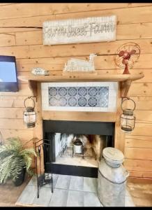 un soggiorno con camino in una parete in legno di Enchanted Farmhouse Cabin a Branson Altre 43 foto