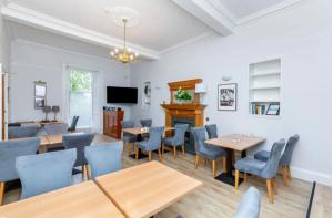 a dining room with tables and chairs and a tv at West Coates Mansion in Edinburgh