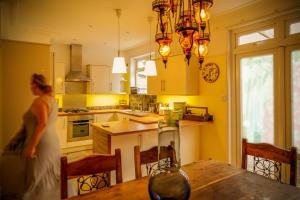 4 bedroom home - N17 في لندن: امرأة تقف في مطبخ مع طاولة