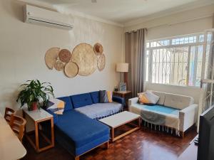 un salon avec un canapé bleu et une table dans l'établissement Casa familiar 2 qts, próx. ao Santuário Nacional, à Aparecida