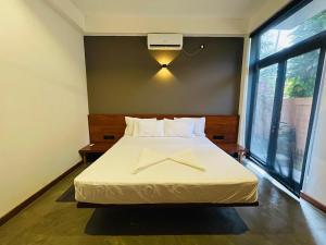 ein Schlafzimmer mit einem Bett mit Kreuz darauf in der Unterkunft Serene Villa in Unawatuna