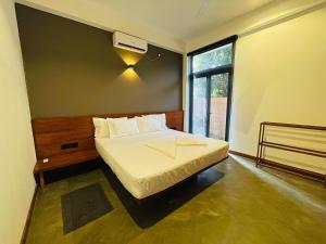 ein Schlafzimmer mit einem großen Bett und einem Fenster in der Unterkunft Serene Villa in Unawatuna + 36 Fotos