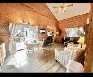 un soggiorno con un divano, un tavolo e delle sedie di Enchanted Farmhouse Cabin a Branson