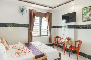 a bedroom with a bed and a table and chairs at Phương Anh 9 Hotel- Only accept Vietnamese customers in Danang