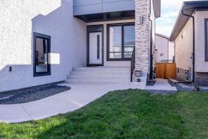 a house with a staircase leading to the front door at Beautiful Brand New 2BR Suite with Private Entrance and free on-site parking in Winnipeg