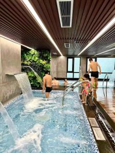 a group of people in a swimming pool at Luxhomes Tonkin2 Vinhomes Smart City in Phú Thú