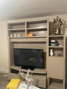 - un centre de divertissement blanc avec une télévision à écran plat dans l'établissement Appartement confortable pour petit budget, au Mans