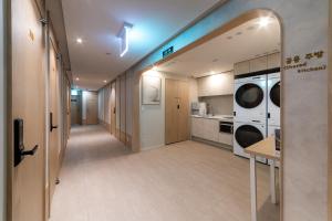 a hallway with a kitchen with a washer and dryer at Hi Seoul Hostel Central in Seoul