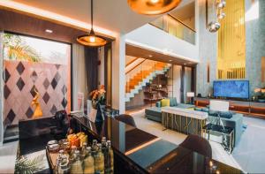 un soggiorno con un divano e un tavolo di Mida Grande Resort 4BR Villa 8123 a Ban Lum Fuang