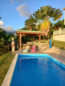 a swimming pool with a gazebo in a yard at Gîte des voyageurs in Vieux-Habitants +7 photos