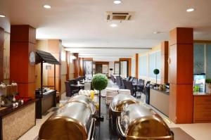 a restaurant with a row of tables and chairs at Horison Kota Lama Semarang in Semarang