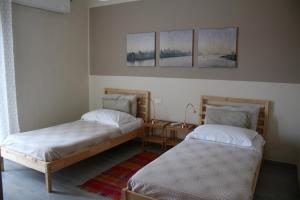 マテーラにあるRiva Dei Sassiのベッドルーム1室(ベッド2台、テーブル、絵画3点付)