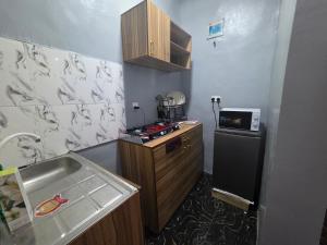 Una pequeña cocina con fregadero y refrigerador. en Prime Gold Apartments, en Lagos
