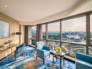 d'une chambre avec des chaises, une table et de grandes fenêtres. dans l'établissement Nanning Champs Elysees Hotel, à Nanning