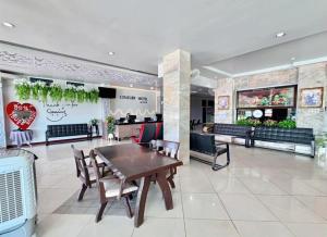 a restaurant with a table and chairs in a lobby at Century Grand Hotel in Bung Kan