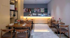 une rangée de tables et de chaises dans un restaurant dans l'établissement danfeng kelly hotel, à Dapengcheng