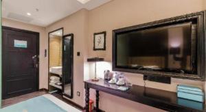 ein Wohnzimmer mit einem großen Flachbild-TV an der Wand in der Unterkunft Xana Hotelle·Suzhou Shilu Shantang Street Scenic Spot in Suzhou