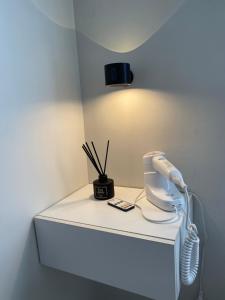 Lifes Good في مانداوي سيتي: طاولة بيضاء عليها هاتف ومصباح