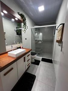 a bathroom with a sink and a shower and a toilet at Casa no centro de Torres in Torres +3 photos