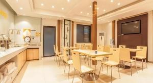 une chambre avec des tables et des chaises dans une cuisine dans l'établissement City Comfort Inn Liuzhou The Mixc Xijiang Road, à Liuzhou