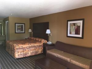 um quarto de hotel com duas camas e um sofá em Executive Inn and Suites Longview em Longview