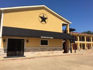 a building with a black awning on the side of it at Executive Inn and Suites Longview in Longview