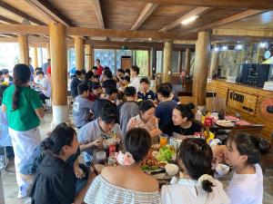 a group of people sitting at tables eating food at O Châu Homestay Lào Cai in Lao Cai