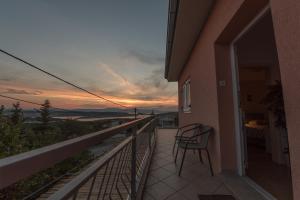 a balcony with a chair and a sunset in the background at Villa Sunset in Jadranovo