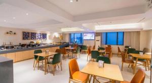 un restaurant avec des tables, des chaises et un comptoir dans l'établissement City Comfort Inn Liuzhou Wuxing Walking Street Zhonghuan Tower, à Liuzhou