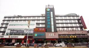 un grand bâtiment avec de nombreux panneaux devant lui dans l'établissement City Comfort Inn Nantong Qidong Renmin Zhong Road Xingfudao, à Huilongzhen