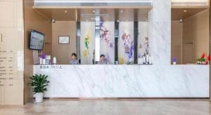 two women standing behind a counter in a lobby at Lavande Hotels· Suizhou Wenfeng in Suizhou