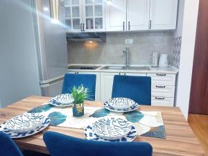 eine Küche mit einem Holztisch mit blauen Stühlen in der Unterkunft Magnolia Lux Apartments in Sokobanja