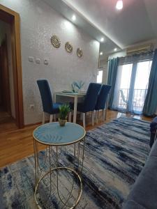 ein Wohnzimmer mit einem Tisch und blauen Stühlen in der Unterkunft Magnolia Lux Apartments in Sokobanja