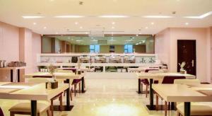 un restaurant avec des tables, des chaises et un comptoir dans l'établissement Lavande Hotels Jinzhong Youjian Pingyao, à Jinzhong