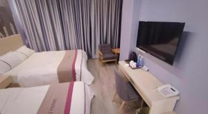 une chambre d'hôtel avec deux lits et une télévision dans l'établissement Thank Inn Hotel Sichuan Zigong Ziliujing District Wuxing Street, à Zigong 174 autres photos