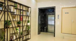 une pièce avec un couloir avec des plantes et une porte dans l'établissement Borrman Hotel Huaian Suning Plaza Huaihai West Road, à Huai'an