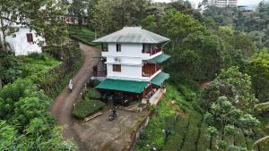 Un edificio blanco en una colina con una casa. en Monte Sereno Munnar, en Anachal 64 fotos más
