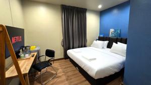 a bedroom with a bed and a desk with a chair at Postel Chinatown in Bangkok
