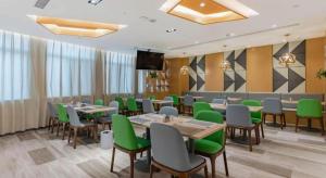 une salle à manger avec des tables et des chaises vertes dans l'établissement GreenTree Eastern Hotel Bengbu Huaishang District Yubo Garden, à Bengbu