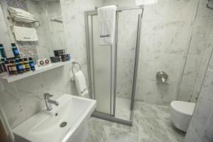 a bathroom with a shower, sink, and toilet at Express İnci Hotel in Istanbul