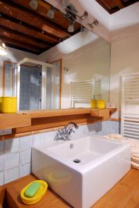 bagno con lavandino bianco e specchio di Feronia - Le Dimore di Borgo Tessile a Orvieto