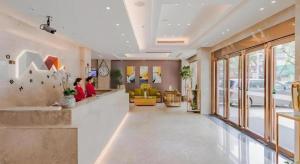 un hall d'un hôpital avec deux personnes assises dans l'établissement Borrman Hotel Huizhou West Lake Shuidong Street, à Huizhou