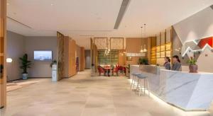 un hall d'entrée avec un restaurant équipé d'une table et de chaises dans l'établissement Borrman Hotel Jining Rencheng District Government Zhongde Plaza, à Liuxing