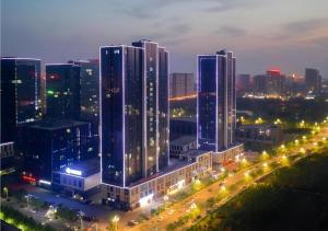 un groupe de grands immeubles dans une ville la nuit dans l'établissement Borrman Hotel Jining Rencheng District Government Zhongde Plaza, à Liuxing