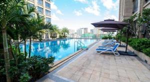 a swimming pool with lounge chairs and an umbrella at Ming Guan Hotel in Sihanoukville