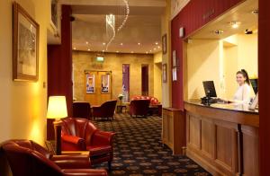 a woman standing at a bar in a waiting room at Leapark Hotel in Grangemouth