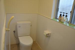 Un pequeño baño con inodoro y ventana. en GOOSESTAY Koza, en Okinawa City