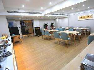a dining room with tables and chairs in a room at GreenTree Inn Luoyang Railway Station Wangfujing Wangcheng Park in Luoyang