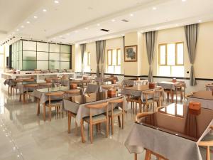 un restaurant avec des tables et des chaises dans une salle dans l'établissement GreenTree Inn Xinjiang Kashgar Food Street, à Kachgar